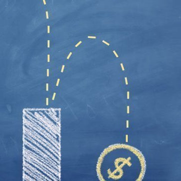 A businessman looking down beside a chalkboard illustration of a declining bar chart and dropping dollar coin.