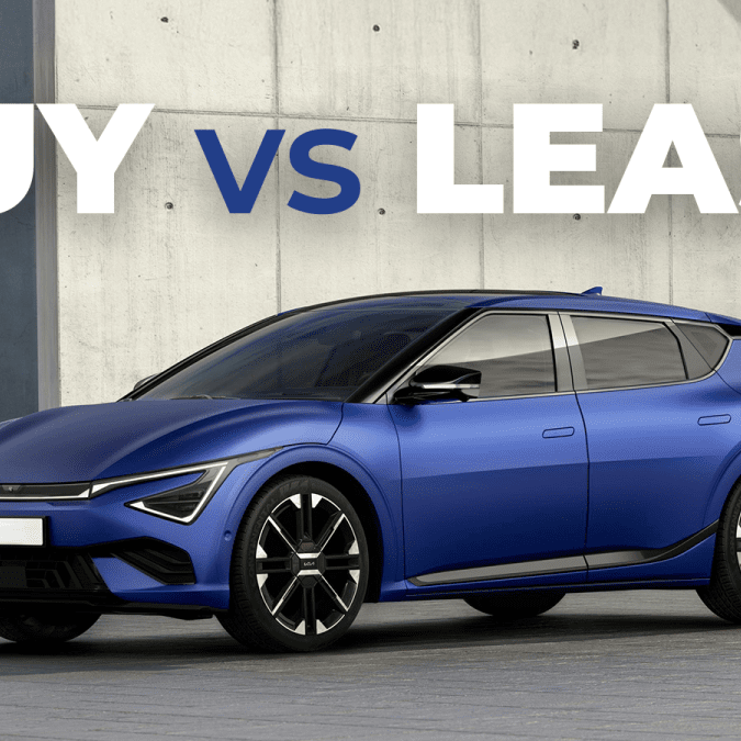 A blue electric vehicle parked in front of a concrete wall, with large text above reading "BUY VS LEASE" in white and blue.